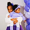 baby, balloons, bow, child, curly_hair, dress, fuzzy_jacket, girl, hands, headband, holding, party_decor, portrait, purple, sibling, skirt, smile, socks, studio_wall, tights