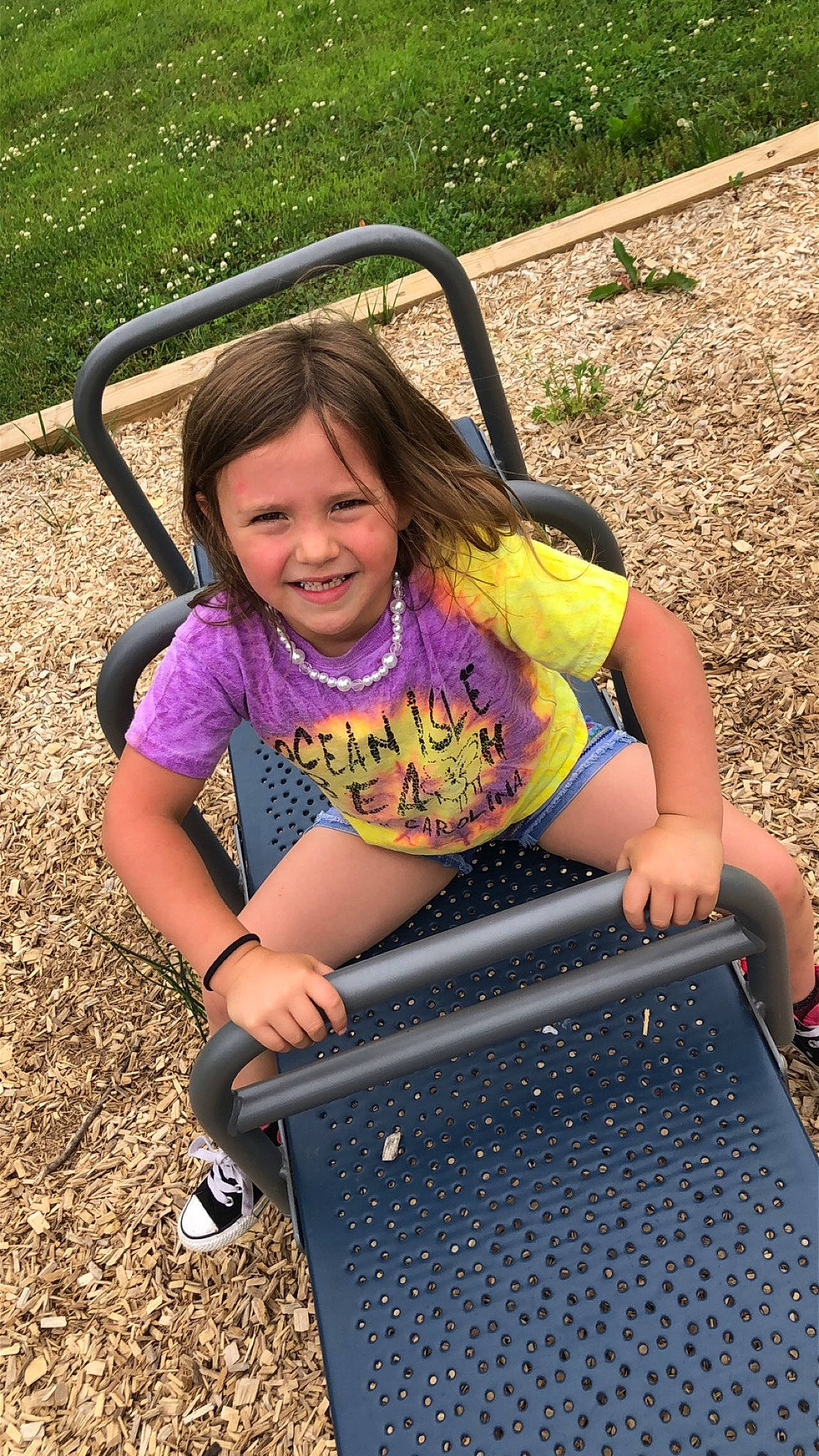 Sophia is registered to the contest to win money with this photo: child, fun, grass, joy, leisure, outdoor_play_equipment, person, play, playground, public_space, sitting, smile, soil, summer, swing, vacation