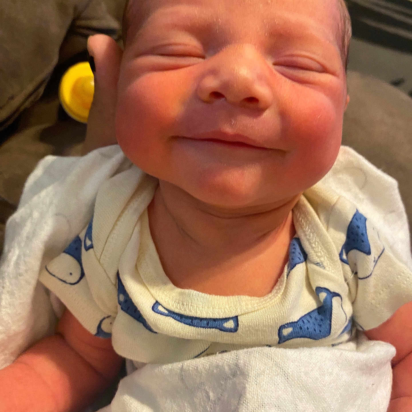 Easteynn is registered to the contest to win money with this photo: baby, blanket, blue_pattern, child, closeup, comfort, couch, face, hand, indoors, infant, newborn, onesie, peaceful, resting, skin, sleepy, smiling, soft_texture, white_clothing