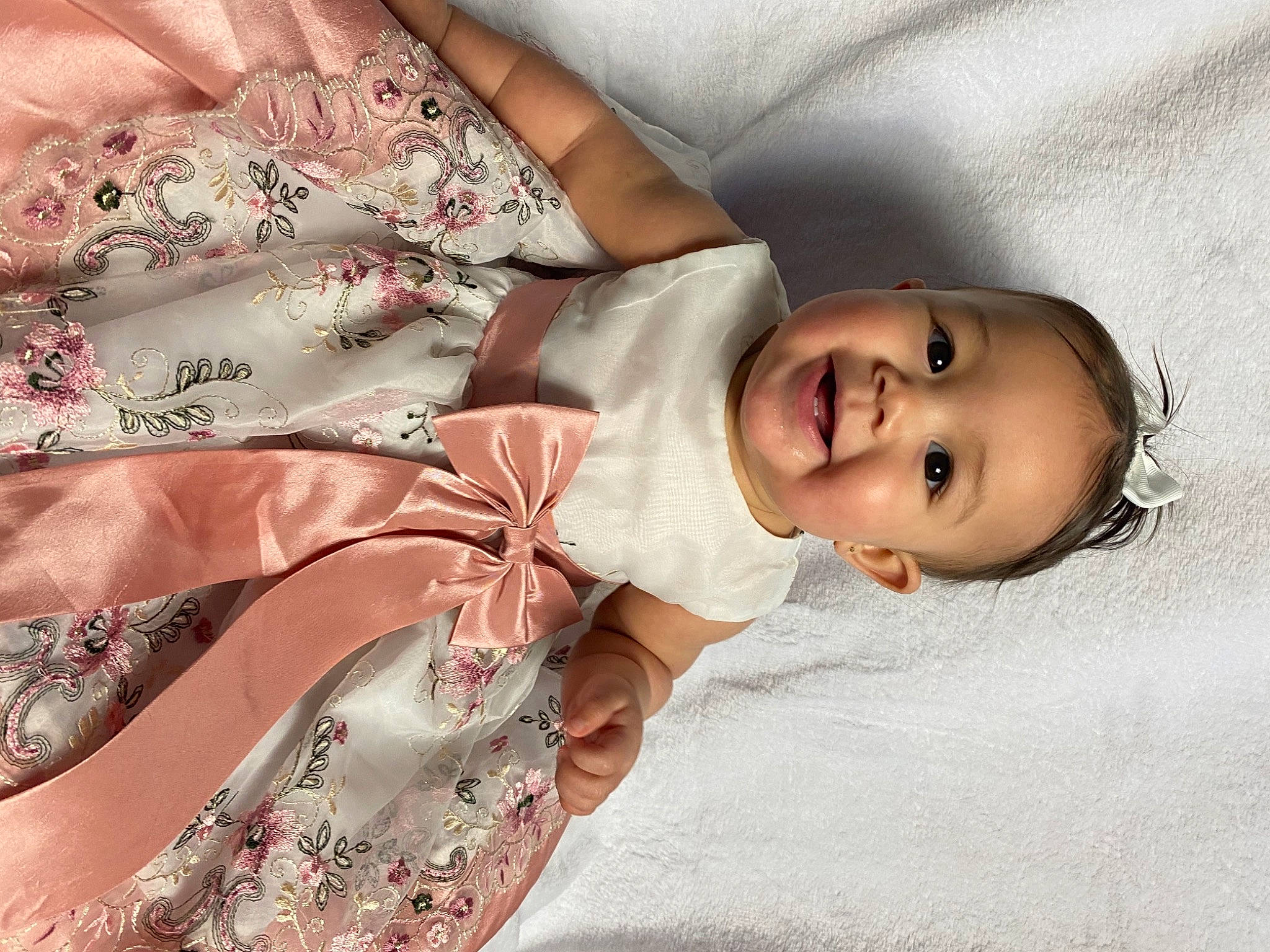 Katiana is registered to the contest to win money with this photo: baby, baby_toddler_clothing, child, comfort, day_dress, dress, dress_shirt, embellishment, eyelash, face, fashion_accessory, joy, linens, lip, pattern, peach, person, pink, skin, sleeve
