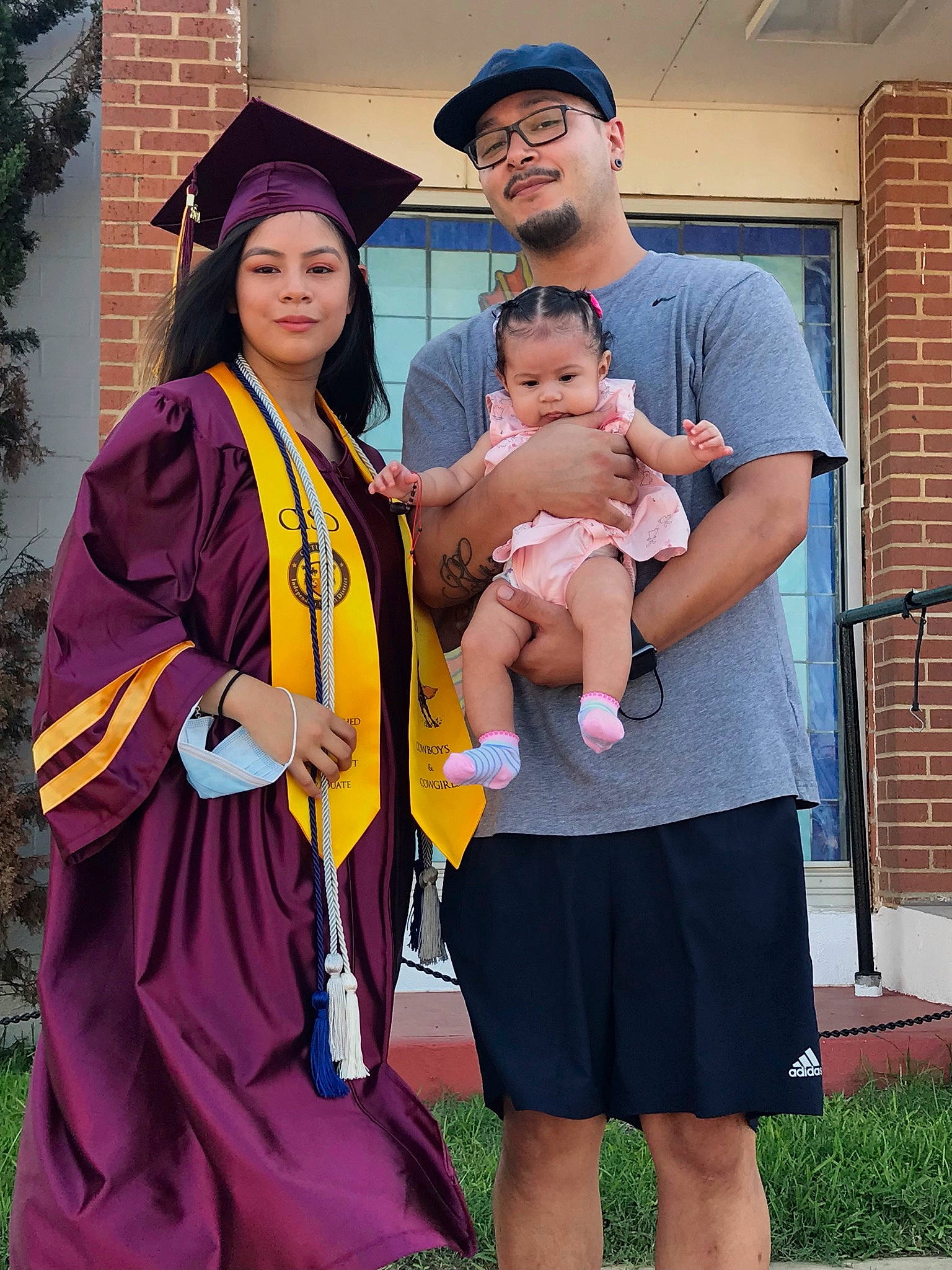 Annalisa is registered to the contest to win money with this photo: academic_dress, baby, blue, costume, event, eyewear, face, fun, grass, happy, hat, headgear, headwear, joy, mortarboard, organ, person, purple, scholar, shorts