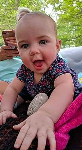 Hazel joined the competition — help win amazing prizes! adaptation, baby, cheek, child, design, facial_expression, finger, grass, hand, pattern, person, play, sitting, skin, smile, toddler