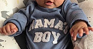 Julien joined the competition — help win amazing prizes! baby, infant, child, blue_clothing, mamas_boy_text, cushion, blanket, bed, indoor, cute, smiling, portrait, hands, legs, face, eyes, cozy, soft_texture, patterned, comfortable
