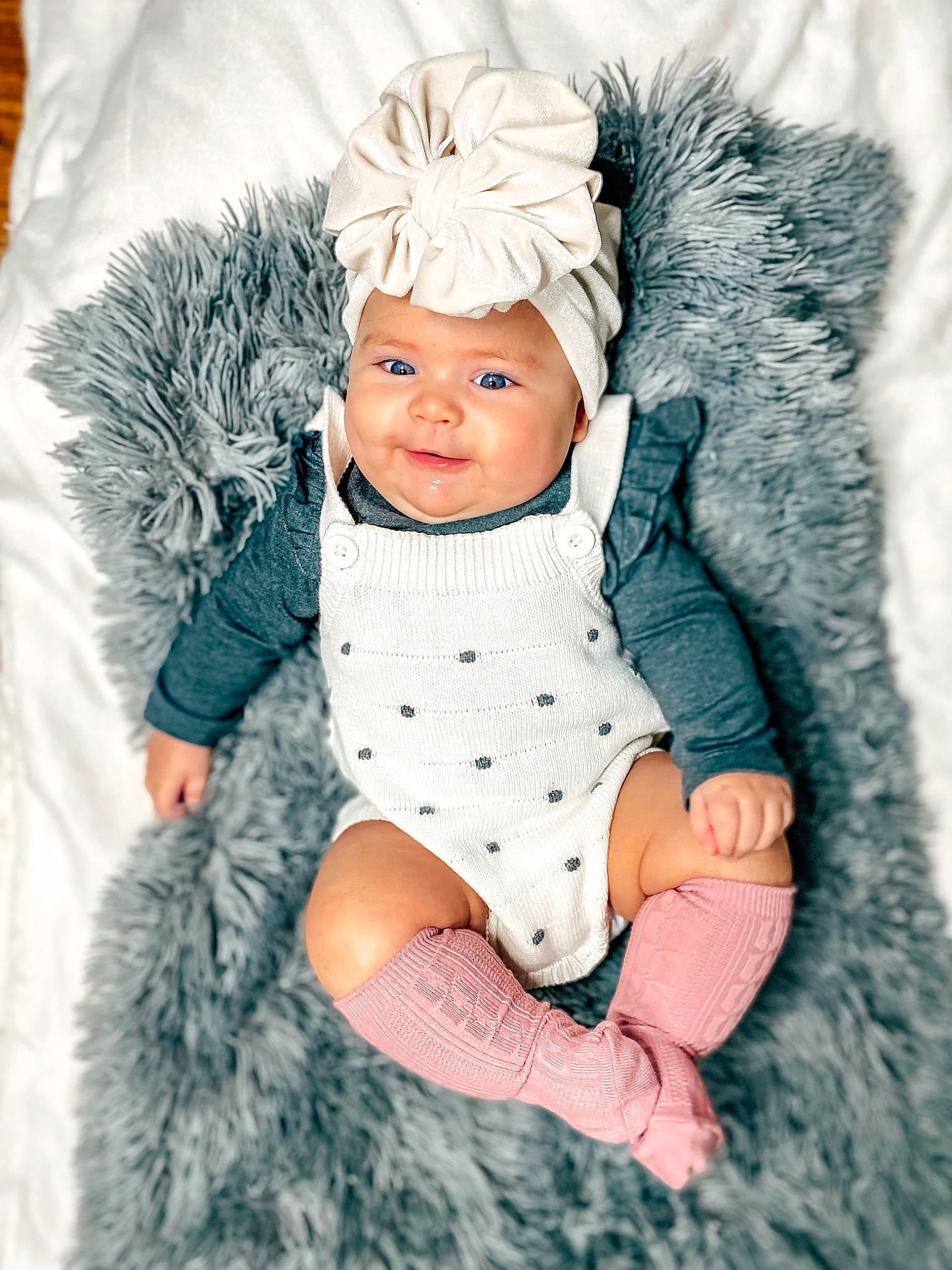 Phoenix is registered to the contest to win money with this photo: arm, azure, baby, baby_toddler_clothing, cap, costume_hat, fur, fur_clothing, gesture, glove, happy, headgear, headwear, human_body, person, skin, sleeve, textile, toddler, tree