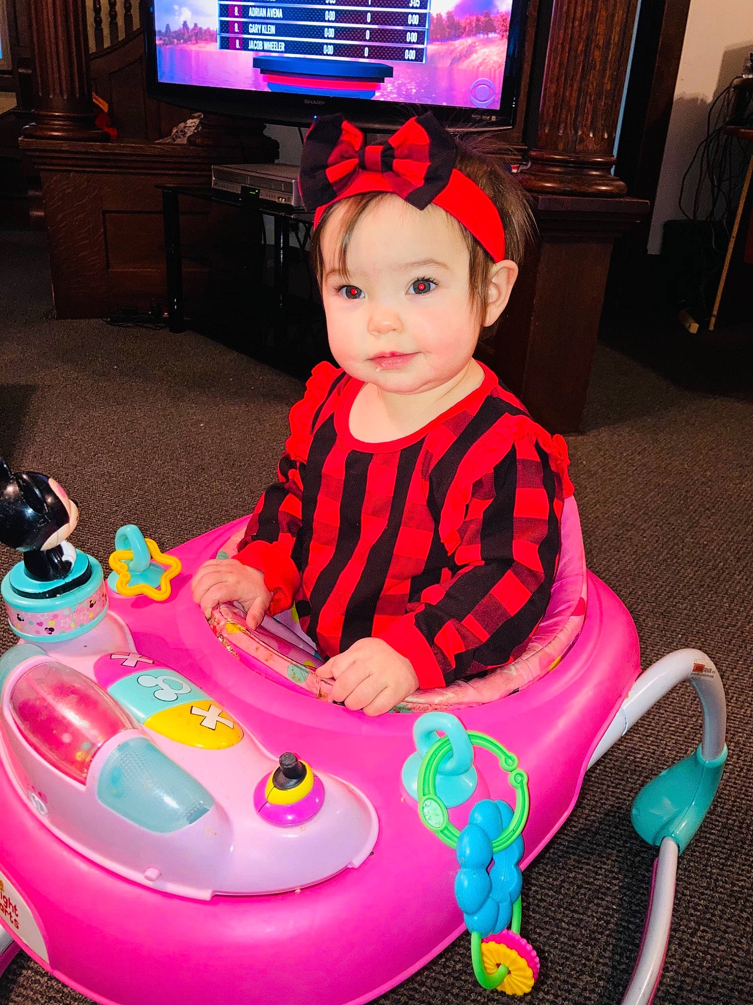 Aryah is registered to the contest to win money with this photo: baby_playing_with_toys, baby_products, baby_toddler_clothing, baby_toys, cabinetry, cable_television, child, display_device, flat_panel_display, headwear, lamp, led_backlit_lcd_display, living_room, person, picture_frame, pink, plastic, play, room, television