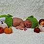 baby, newborn, sleeping, green_hat, knitwear, plush_pumpkins, white_blanket, soft_texture, autumn_theme, cozy, infant, cute, lying_down, child, hat, orange, brown, cream, decor, portrait