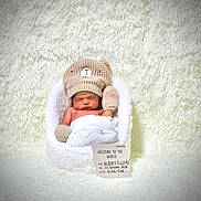 Avery joined the competition — help win amazing prizes! newborn, baby, sleeping, knitted_hat, mittens, basket, white_background, soft_texture, fluffy, welcome_card, portrait, cute, infant, cozy, baby_clothing, peaceful, child, studio_photo, warm, resting
