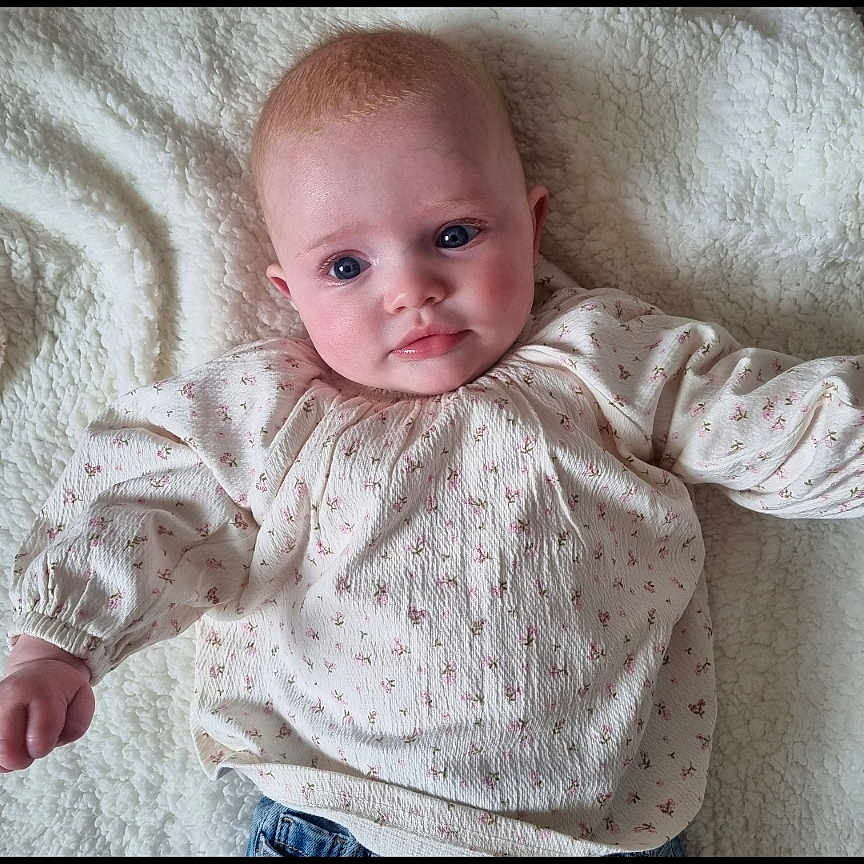 Edie-Mae is registered to the contest to win money with this photo: baby, bed, bodypart, clothing, face, finger, hand, happy, head, homedecor, longsleeve, newborn, pants, person, photography, portrait, quilt, sitting, sleeve, smile