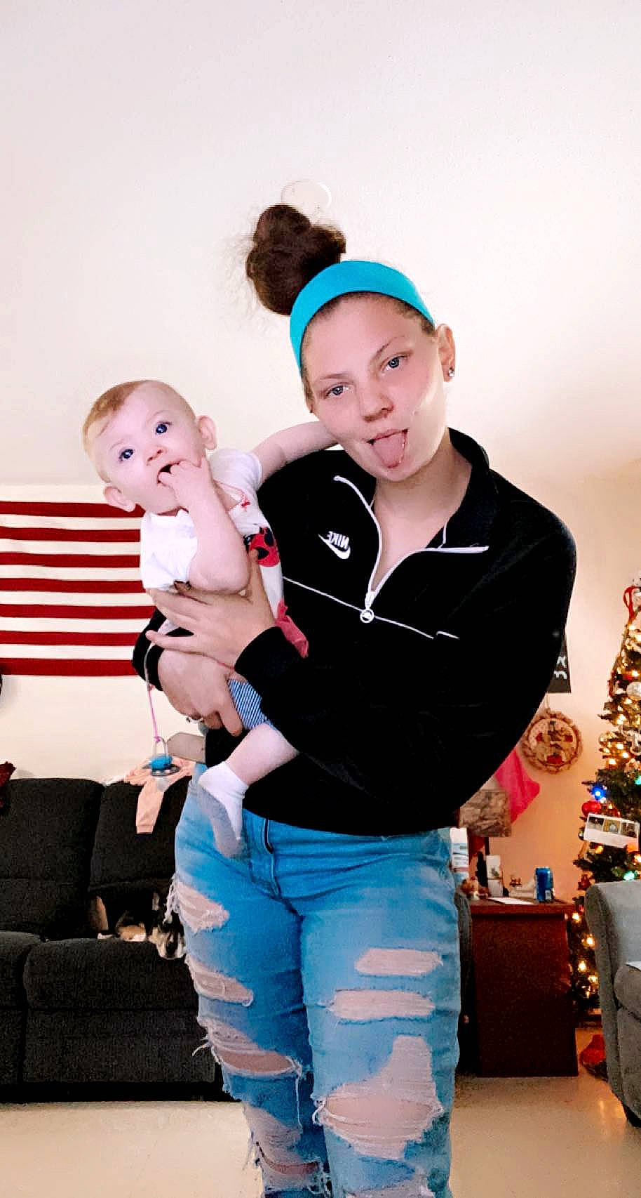 Dixie is registered to the contest to win money with this photo: baby, belt, child, christmas_decoration, christmas_tree, couch, electric_blue, event, facial_expression, fashion, flash_photography, fun, fur, happy, jewellery, leisure, person, sitting, smile, surprise