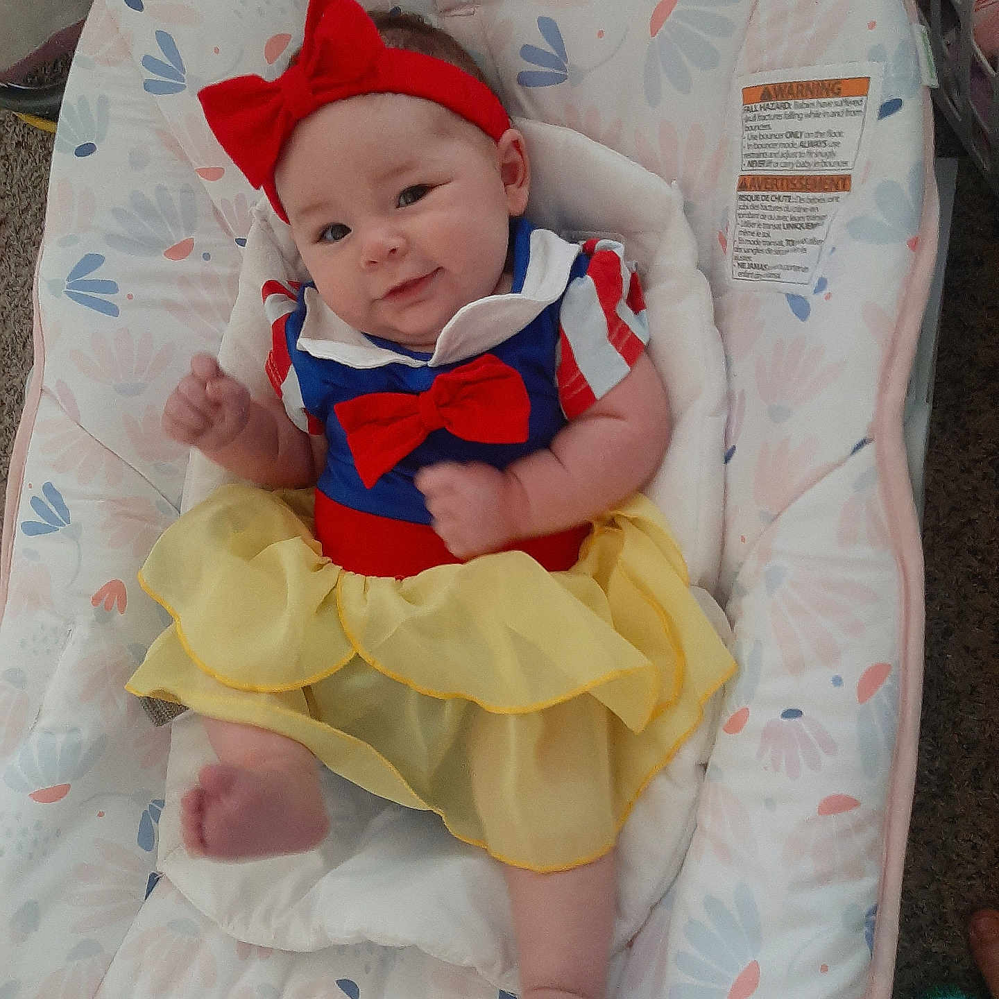 Muireann joined the competition — help win amazing prizes! baby, baby_seat, blue_top, carpet, child, clothing, cute, floral_pattern, footwear_absent, furniture, happy, headband, indoor, infant, person, portrait, red_bow, skin, smile, yellow_skirt