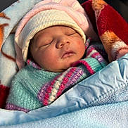 Coco joined the competition — help win amazing prizes! baby, newborn, sleeping, blanket, hat, cozy, warm, face, closeup, child, infant, soft, cute, wrapped, portrait, rest, peaceful, colorful, clothing, toddler