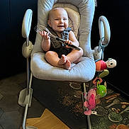Elena a rejoint le concours — aidez-le/la à gagner de superbes lots ! baby, baby_rocker, child, colorful, cushion, fabric, floor_mat, footwear, happy, indoor, infant, kitchen, person, plastic, playful, seat, smiling, toy, whisk, wood_floor