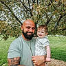 Waylan joined the competition — help win amazing prizes! man, baby, child, person, smile, beard, tattoo, outdoor, tree, flower, grass, nature, green, holding, happy, casual_clothing, daylight, portrait, family, parent