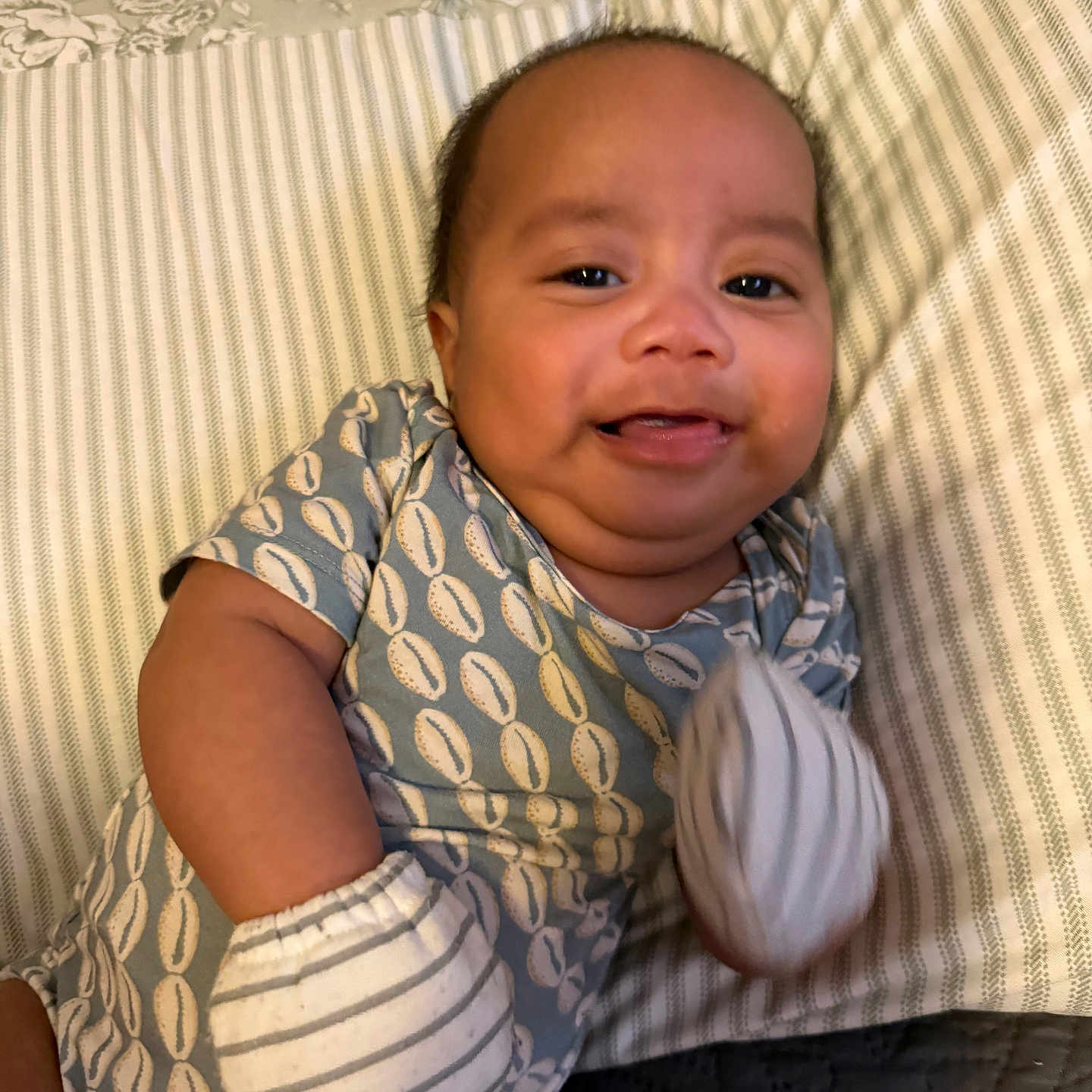 Jruziah joined the competition — help win amazing prizes! baby, child, closeup, clothing, cozy, cute, face, handwear, happy, indoor, infant, lying_down, mittens, onesie, patterned, pillow, portrait, smiling, striped, young