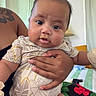 Jruziah joined the competition — help win amazing prizes! baby, child, closeup, clothing, colorful, curtains, cushion, eyes, face, furniture, hand, holding, indoor, infant, mouth, patterned_clothing, person, skin, sofa, tattoo