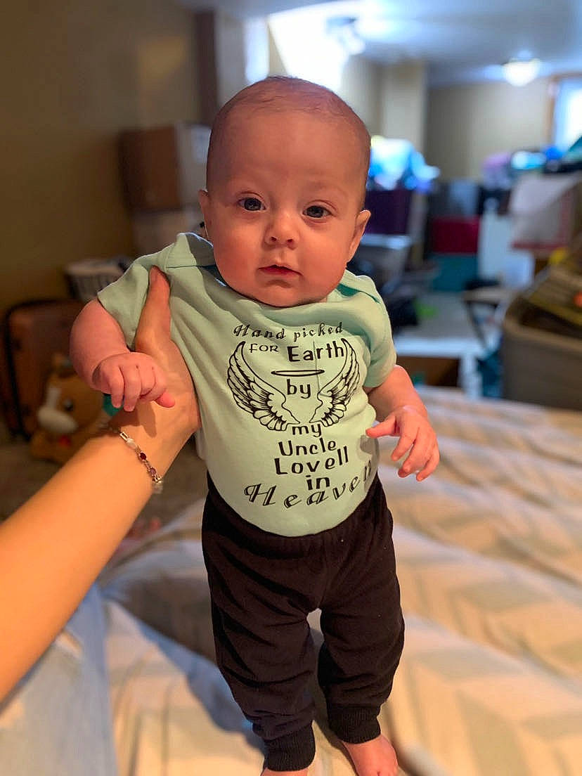 Lovell is registered to the contest to win money with this photo: baby, baby_toddler_clothing, chair, cheek, child, chin, comfort, elbow, flooring, fun, gesture, happy, leisure, person, sitting, skin, sleeve, t_shirt, thumb, toddler