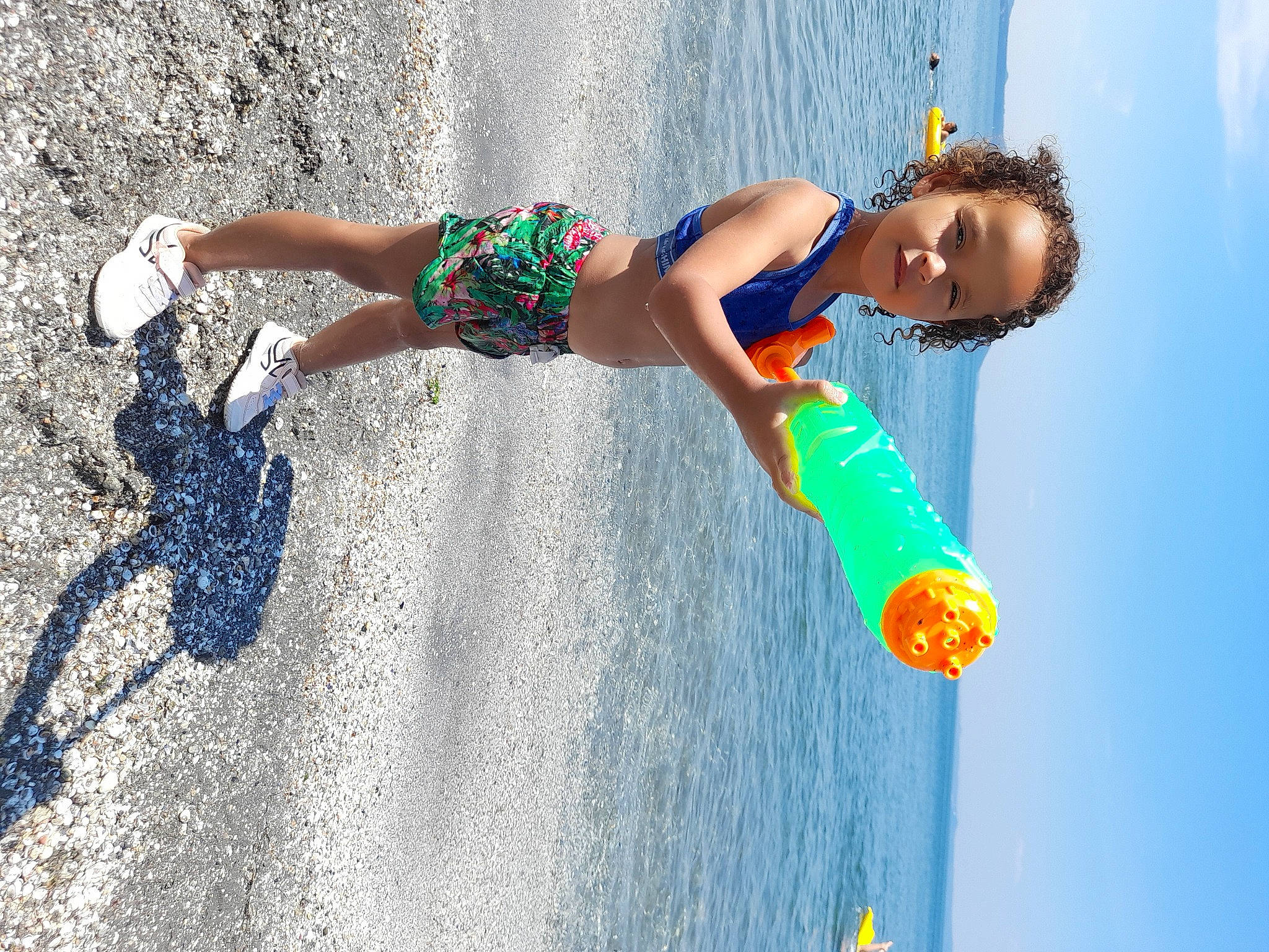 Amira participe au concours pour gagner de l'argent avec cette photo : azure, barefoot, beach, body_of_water, elbow, electric_blue, fun, happy, leisure, people_in_nature, people_on_beach, person, recreation, sand, shorts, skimboarding, sky, surfing_equipment, toddler, water