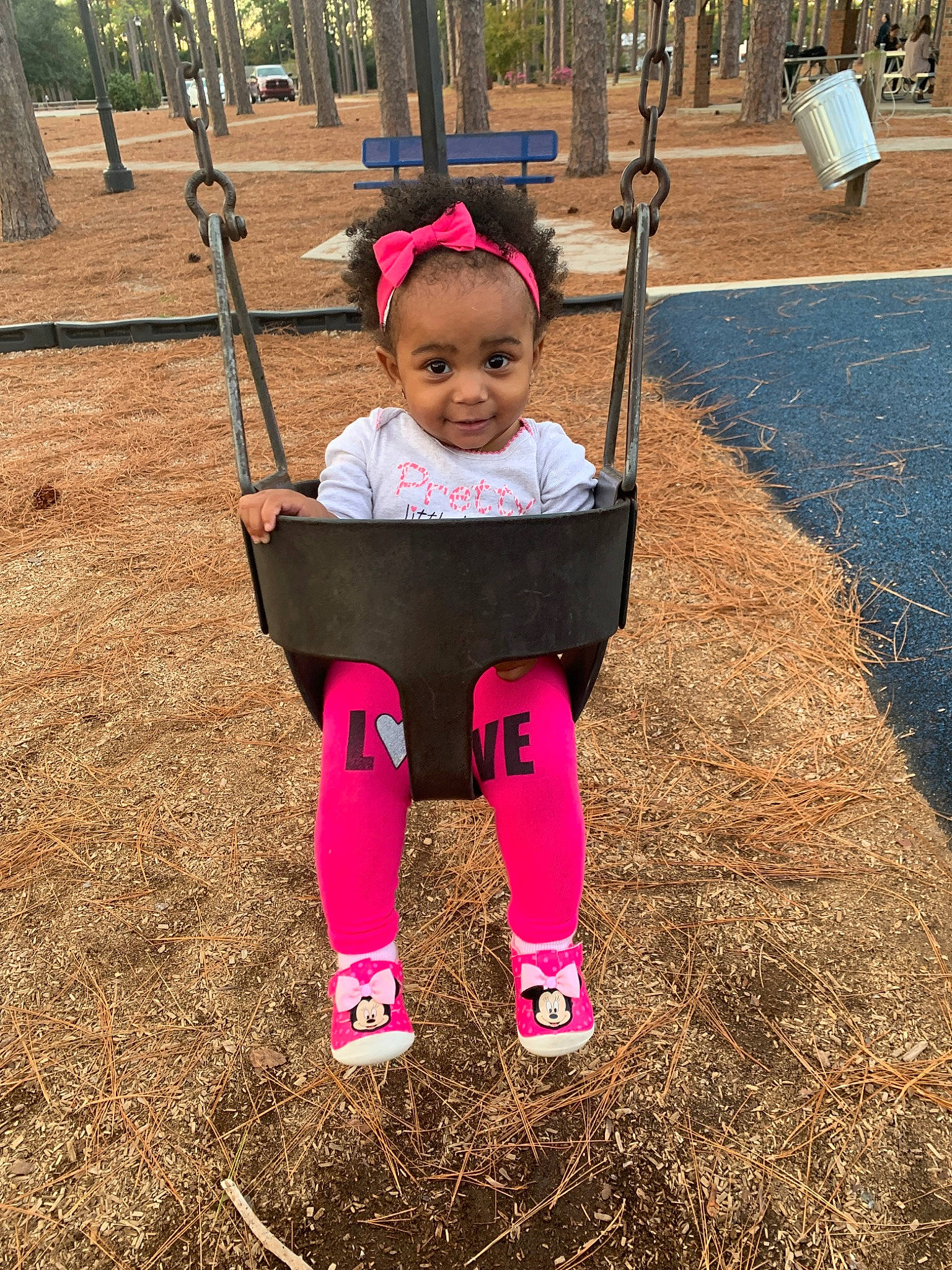 Amia is registered to the contest to win money with this photo: child, fun, human_settlement, joy, outdoor_play_equipment, person, pink, plant, play, playground, public_space, recreation, smile, swing, toddler, tree