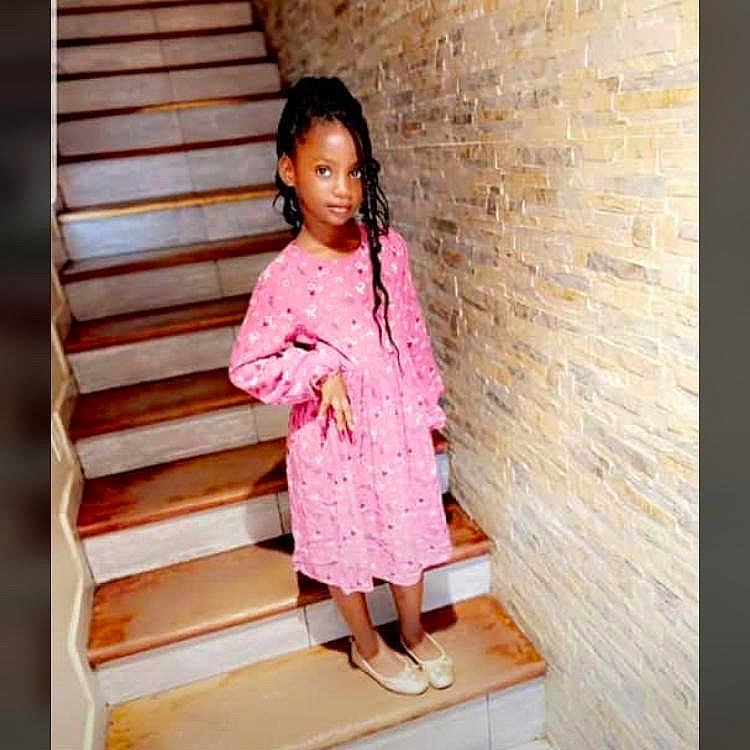 Layanna a rejoint le concours — aidez-le/la à gagner de superbes lots ! architecture, blackhair, building, child, clothing, coat, face, female, footwear, girl, hair, head, house, housing, person, raincoat, shoe, sitting, sleeve, staircase