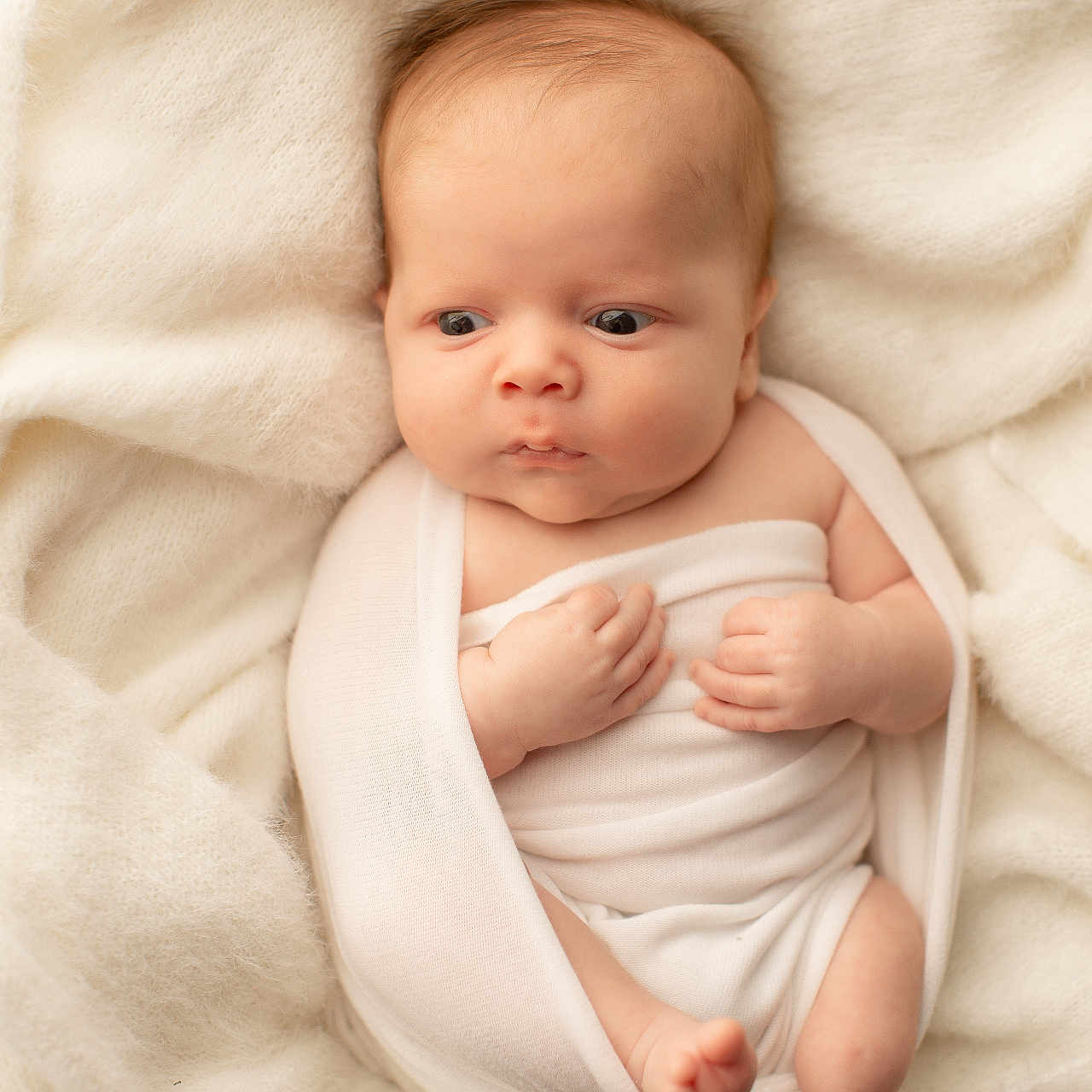 Phoenix is registered to the contest to win money with this photo: baby, infant, newborn, wrapped, blanket, soft, white, cute, skin, hands, feet, portrait, expression, lying_down, indoors, warm, cozy, child, person, sleepwear