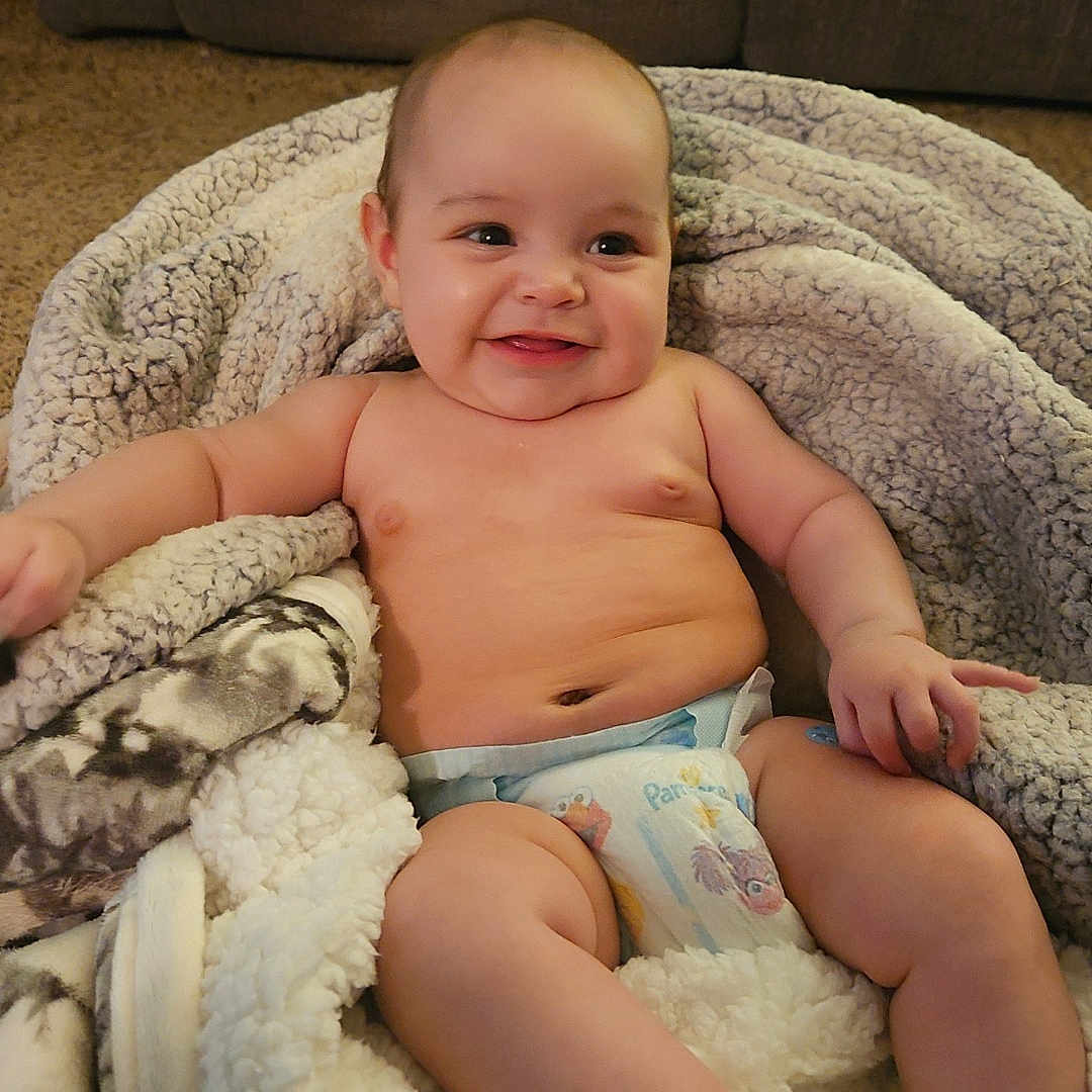Irie joined the competition — help win amazing prizes! baby, smiling, blanket, diaper, couch, carpet, indoor, happy, chubby, skin, cute, infant, person, relaxing, comfort, cozy, portrait, soft, warm, furniture