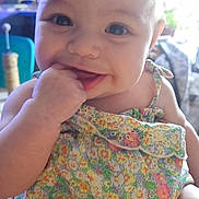 Irie joined the competition — help win amazing prizes! baby, smiling, indoor, child, face, hand, clothing, floral_dress, cute, happy, person, infant, portrait, skin, eyes, fingers, sitting, young_child, closeup, bright