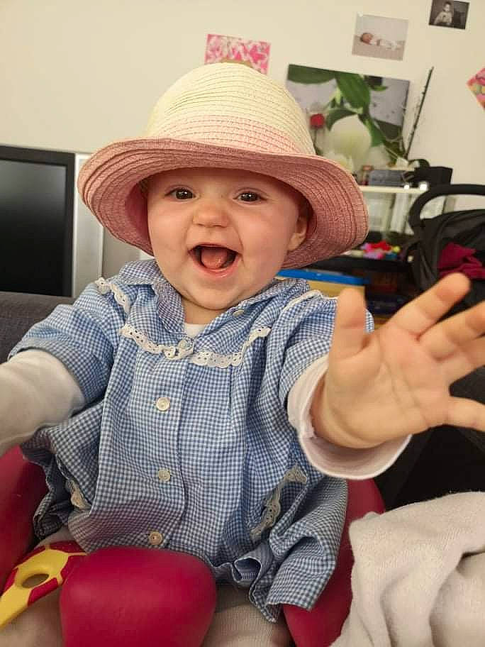 Victoire participe au concours pour gagner de l'argent avec cette photo : baby, baby_toddler_clothing, cap, cheek, child, fashion_accessory, fun, happy, hat, headgear, headwear, organ, pattern, people, person, picture_frame, sitting, skin, smile, sun_hat