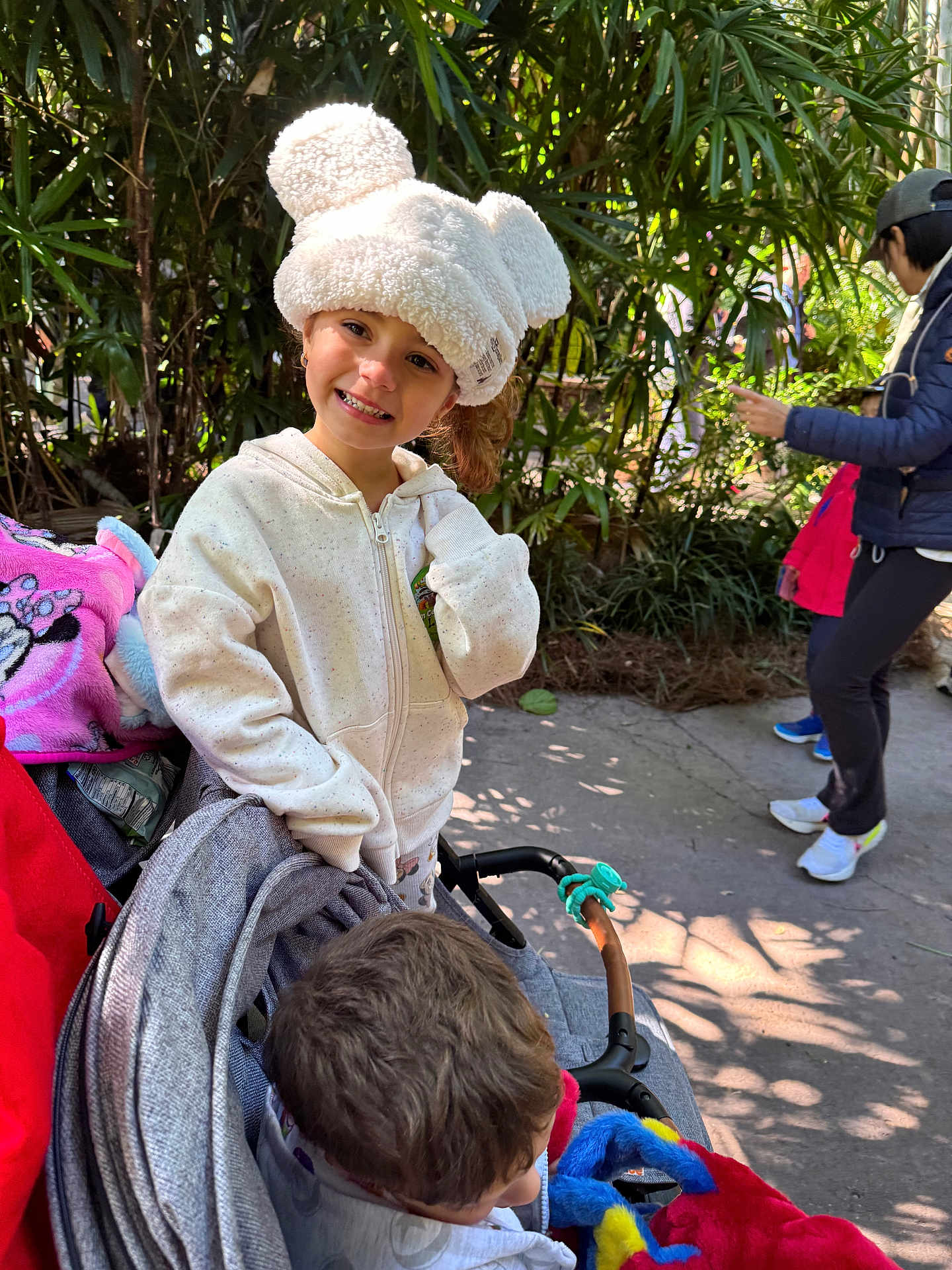 Girl joined the competition — help win amazing prizes! boy, casual_clothing, child, daylight, family, girl, greenery, happy, hat, hoodie, jacket, outdoor, park, person, plants, playful, smile, stroller, walking, white_hat