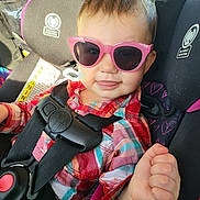 Lilly joined the competition — help win amazing prizes! toddler, child, sunglasses, car_seat, car, seatbelt, plaid_shirt, hand, thumbs_up, face, person, safety, child_seat, sunlight, interior, cute, smile, young_child, fashion, accessory