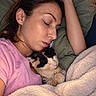 Vénus participe au concours pour gagner de l'argent avec cette photo : woman, cat, calico_cat, sleeping, snuggling, bed, blanket, pillow, cozy, indoors, portrait, close_up, relaxed, peaceful, pink_shirt, brown_hair, pet, whiskers, warm_lighting, home