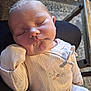 baby, sleeping, infant, face, clothing, sleeve, hand, resting, indoor, blanket, pattern, table, floor, head, cute, peaceful, closed_eyes, skin, person, newborn
