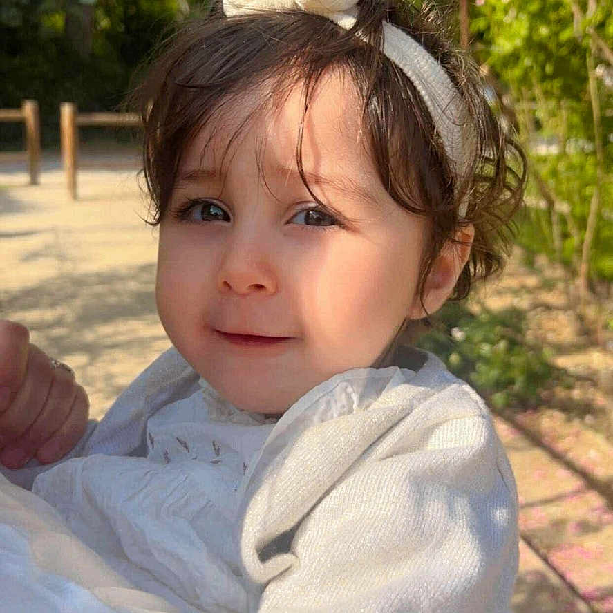 Soujoud Hammadi participe au concours pour gagner de l'argent avec cette photo : baby, baby_girl, child, clothing, cute, daylight, face, greenery, hair, happy, head, headband, nature, outdoor, person, portrait, skin, smile, sunlight, toddler