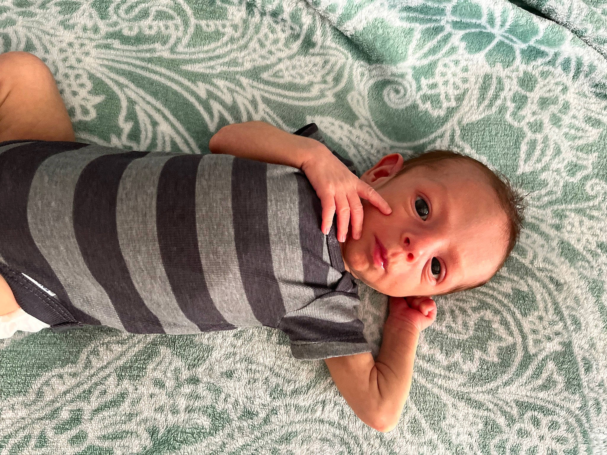 Cohan is registered to the contest to win money with this photo: arm, baby, baby_products, baby_toddler_clothing, bedding, child, comfort, elbow, grass, human_body, human_leg, linens, pattern, person, skin, sleeve, sock, textile, toddler, waist