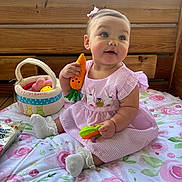 Camilla is registered to the contest to win money with this photo: baby, child, pink_dress, carrot_toy, easter_basket, floral_blanket, wooden_bench, indoor, cute, sitting, sock, toy, plush, face, happy, girl, portrait, playful, easter, decor
