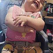 Scarlette joined the competition — help win amazing prizes! baby, child, smile, laugh, high_chair, bib, pink_clothing, winnie_the_pooh, pants, barefoot, indoor, kitchen, wood_paneling, clock, utensils, seatbelt, happy, cute, person, furniture