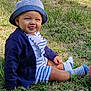 baby, child, grass, hat, striped_clothing, cardigan, socks, tongue_out, outdoor, cute, smiling, sitting, nature, sunlight, happy, person, infant, casual_wear, summer, playful