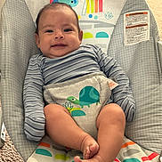 Malachi is registered to the contest to win money with this photo: baby, infant, smile, striped_clothing, baby_seat, colorful, rainbow, turtle, monkey, elephant, indoor, carpet, cute, child, young, happy, portrait, sitting, playful, soft_lighting