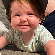 Chelsea Reed joined the competition — help win amazing prizes! baby, child, cap, smile, face, couch, floral_clothing, indoor, person, cute, happy, infant, toddler, skin, hand, headwear, portrait, young_child, lying_down, cheeks