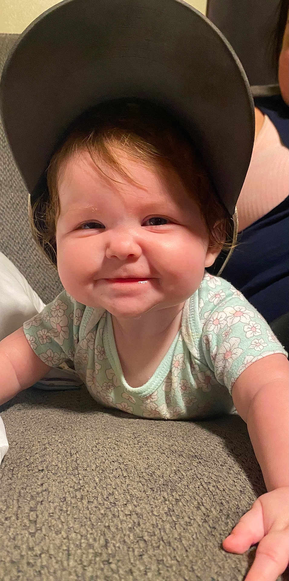 Chelsea Reed joined the competition — help win amazing prizes! baby, child, cap, smile, face, couch, floral_clothing, indoor, person, cute, happy, infant, toddler, skin, hand, headwear, portrait, young_child, lying_down, cheeks