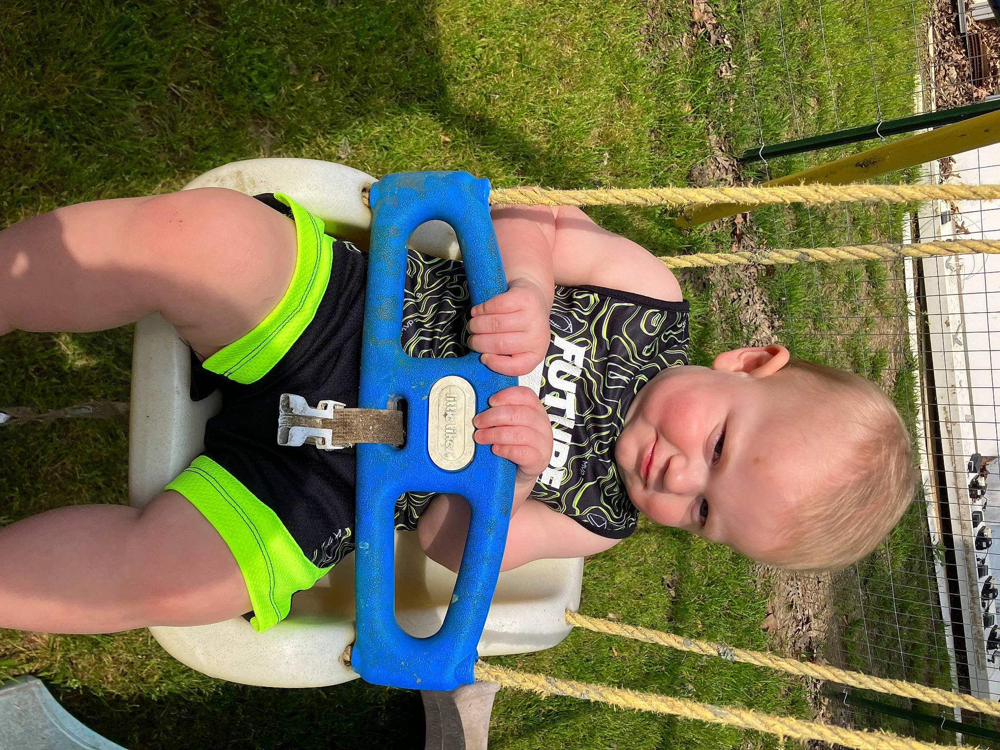 Ashton is registered to the contest to win money with this photo: baby, chest, child, cycling_shorts, electric_blue, fun, grass, happy, human_leg, knee, leisure, people_in_nature, person, personal_protective_equipment, recreation, shorts, sportswear, thigh, toddler, tree