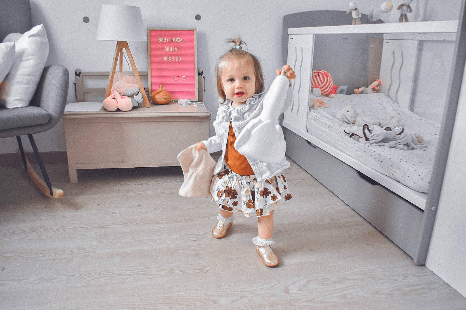 Giulia participe au concours pour gagner de l'argent avec cette photo : baby, baby_toddler_clothing, chair, comfort, couch, dress, floor, flooring, happy, hardwood, house, leg, living_room, person, picture_frame, room, sitting, sleeve, textile, toddler