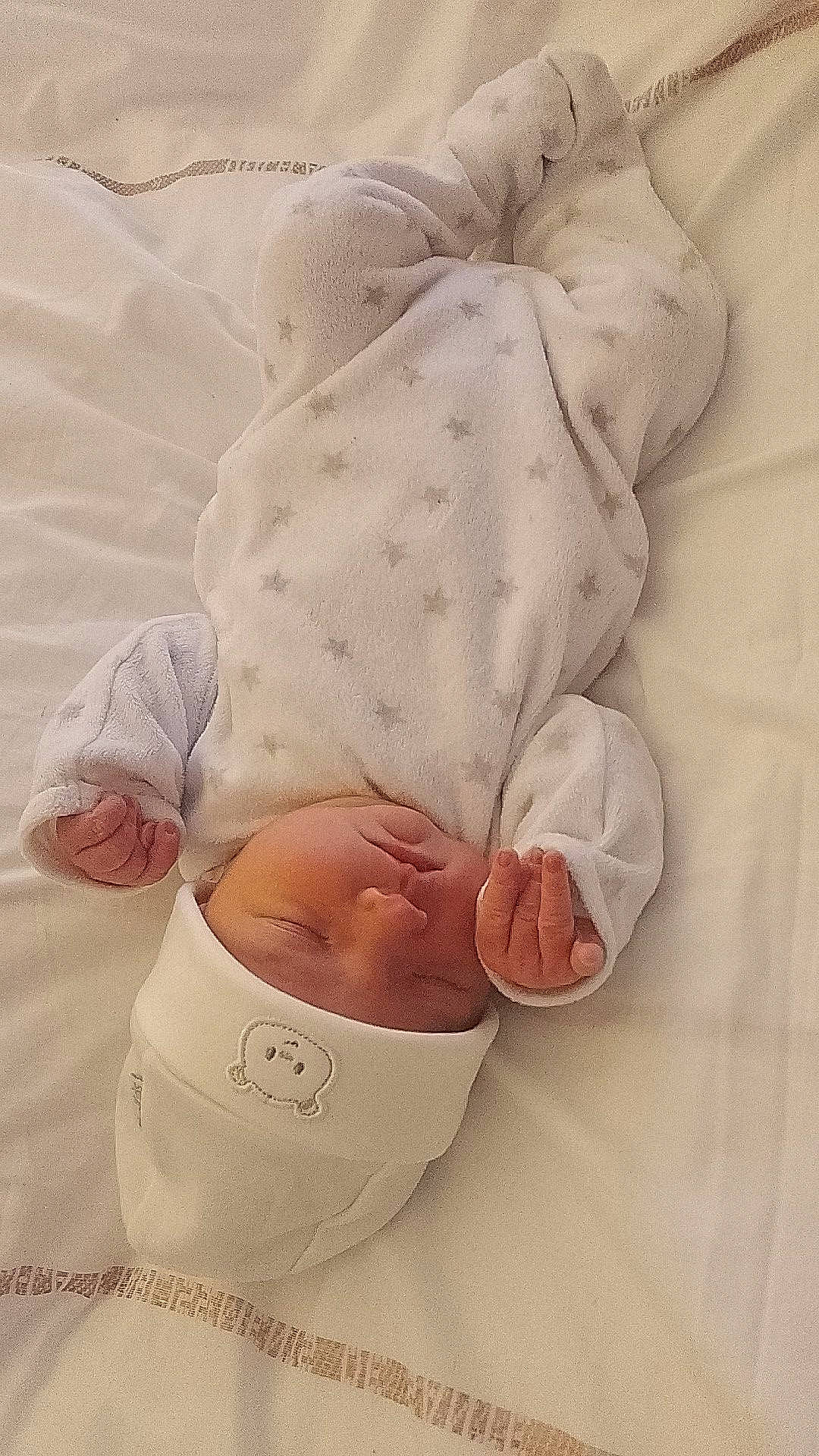 Juliette a rejoint le concours — aidez-le/la à gagner de superbes lots ! baby, baby_products, baby_sleeping, baby_toddler_clothing, barefoot, bedding, child, comfort, elbow, finger, foot, gesture, headwear, human_leg, knee, linens, nail, person, sitting, sleeve