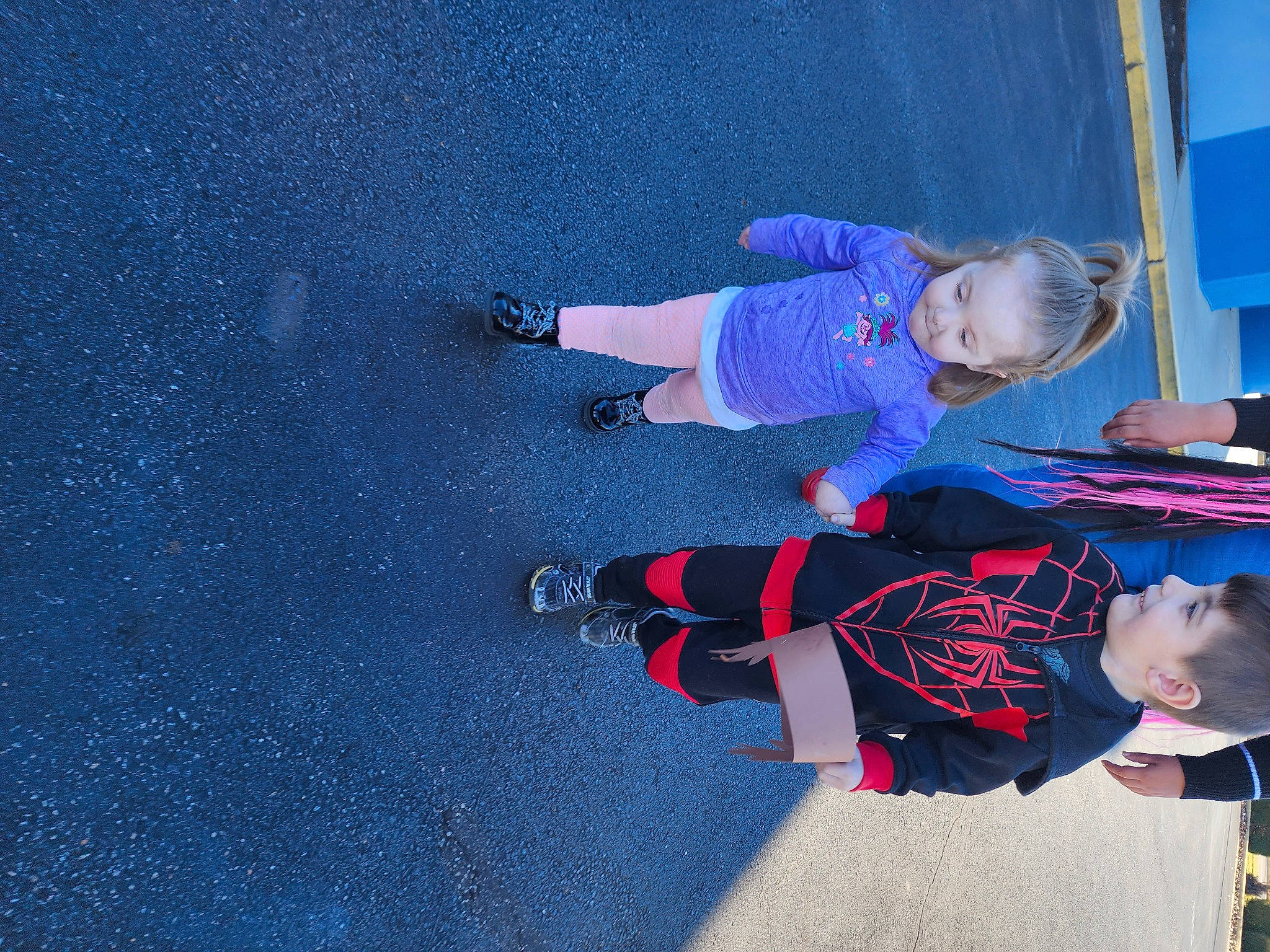Tyler is registered to the contest to win money with this photo: asphalt, azure, blue, carmine, child, concrete, electric_blue, flooring, fun, leisure, pedestrian, person, play, recreation, road_surface, shadow, sidewalk, smile, tar, toddler
