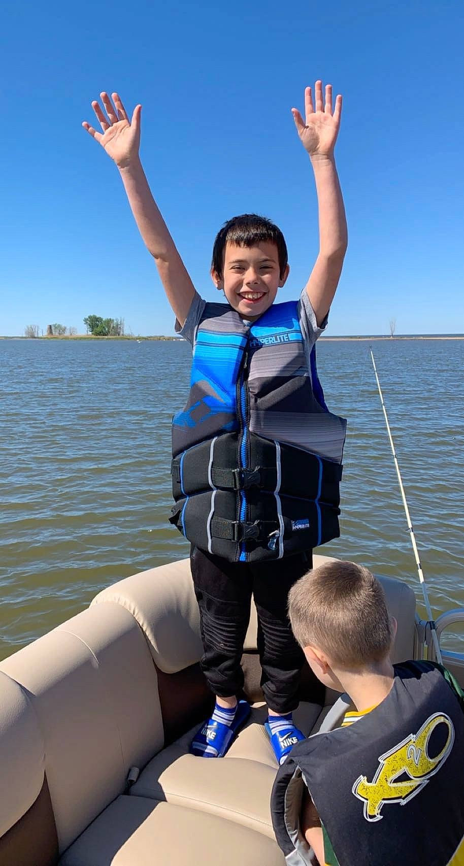 Tristian is registered to the contest to win money with this photo: blue, boats_and_boating_equipment_and_supplies, electric_blue, fun, gesture, happy, joy, lake, leisure, lifejacket, person, personal_protective_equipment, recreation, sky, smile, t_shirt, thumb, travel, water, water_transportation