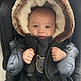 baby, blue_eyes, car_seat, child, cold_weather, cute, expression, fur_hood, hands, headwear, indoors, infant, jacket, portrait, seatbelt, snug, soft_texture, tiny, warm_clothing, winter_coat