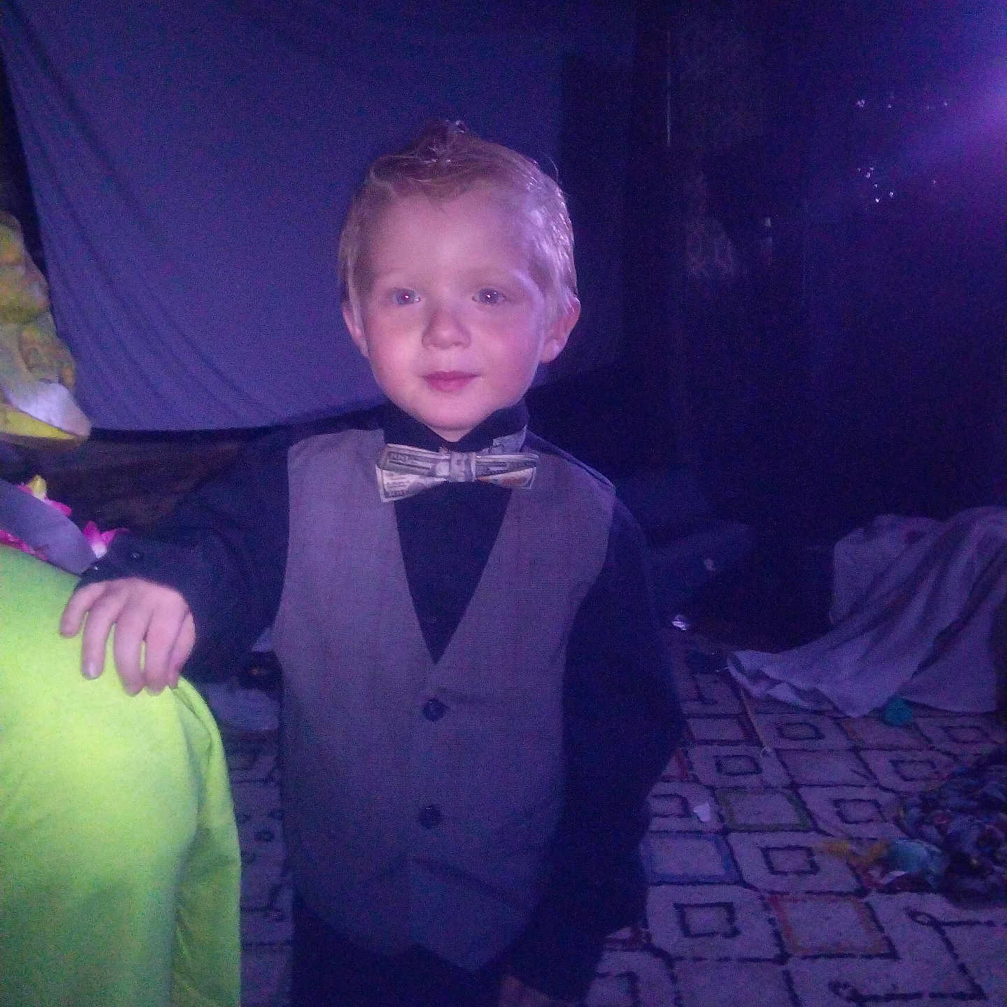 Zane joined the competition — help win amazing prizes! child, boy, toddler, portrait, bow_tie, vest, formalwear, smiling, standing, indoors, bedroom, bed, blanket, colorful, purple_lighting, flash_photography, patterned_bedding, short_hair, young_person, celebration