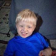 Zane joined the competition — help win amazing prizes! child, boy, blond_hair, smiling, grinning, blue_shirt, portrait, indoors, living_room, couch, rug, furniture, seated, toy, holding_object, happy, face, head, arm, casual_clothing