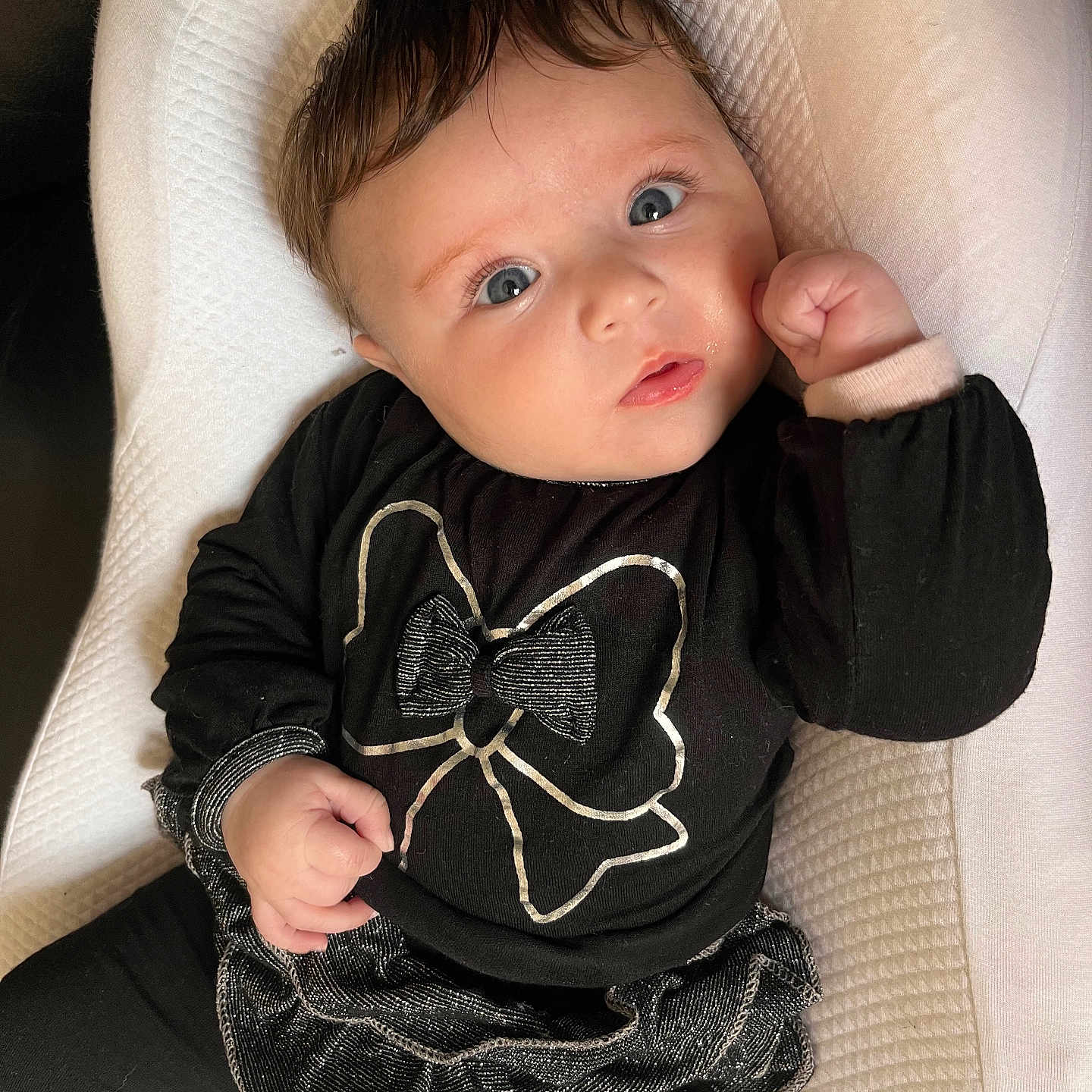 Soleya participe au concours pour gagner de l'argent avec cette photo : baby, black_clothing, blue_eyes, bow, child, cushion, cute, expression, fashion, fist, hair, indoors, infant, long_sleeves, looking_up, portrait, relaxing, soft_texture, tiny_hand, white_background