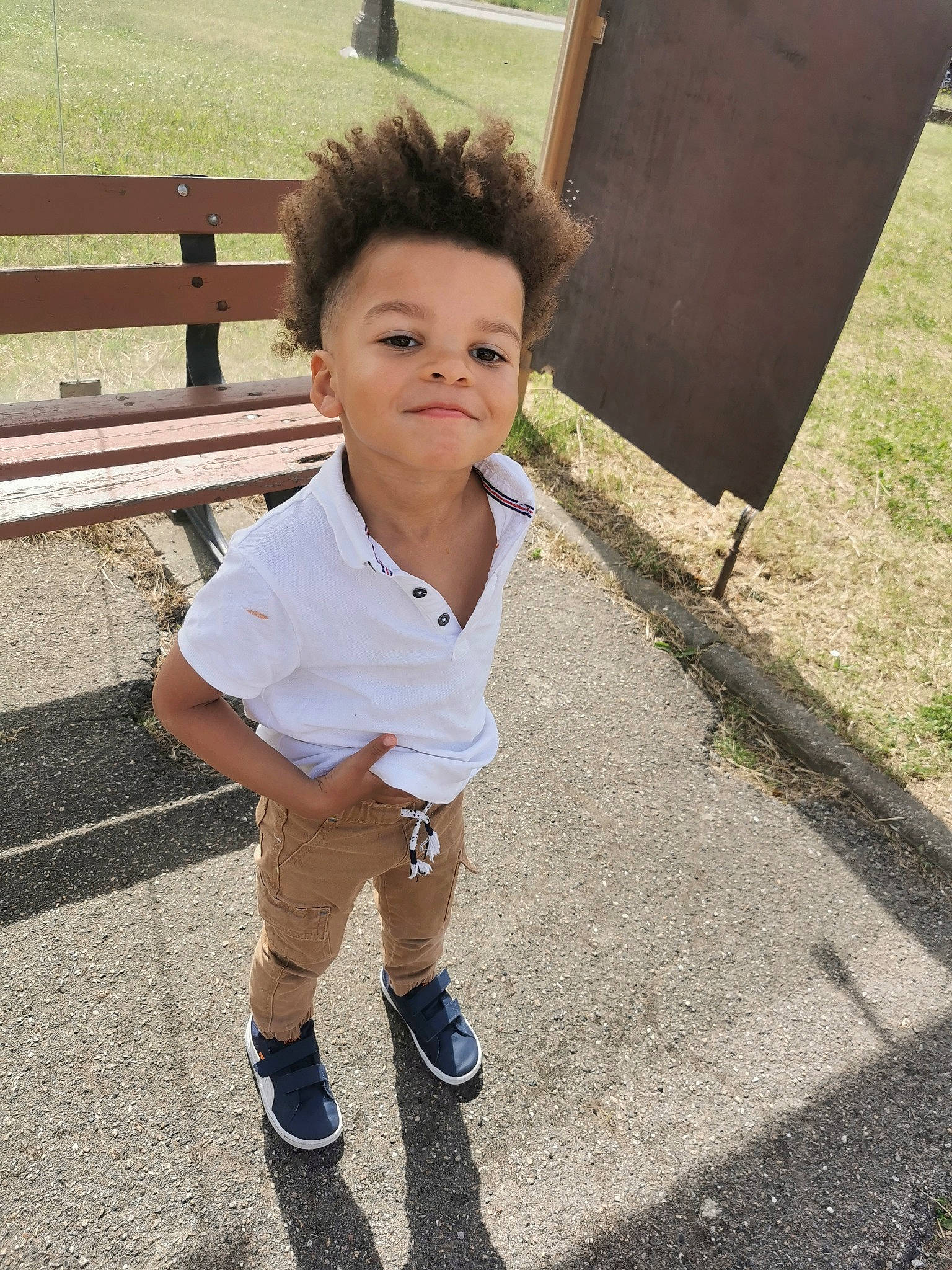 Lewis participe au concours pour gagner de l'argent avec cette photo : asphalt, child, fence, flash_photography, fun, grass, happy, human_leg, leisure, person, play, road_surface, shadow, shorts, sitting, sleeve, smile, t_shirt, toddler, vacation