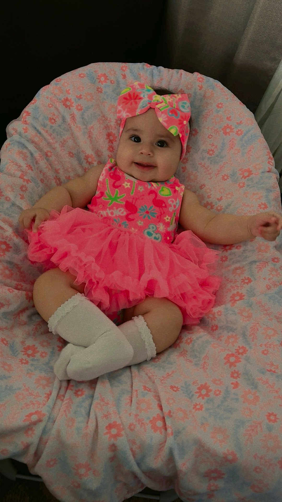 Nicolette joined the competition — help win amazing prizes! baby, infant, smile, pink_dress, headband, socks, blanket, floral_pattern, cute, child, indoors, soft_fabric, happy, portrait, tutu, sitting, comfortable, adorable, clothing, person